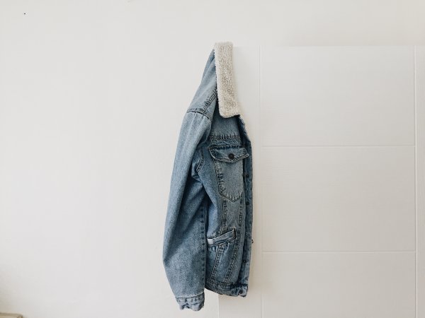 A blue denim jacket hanged by the door.
